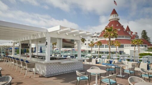 outdoor bar with seating and hotel in the background